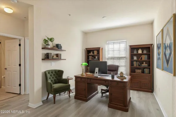 a view of a workspace with furniture and a window