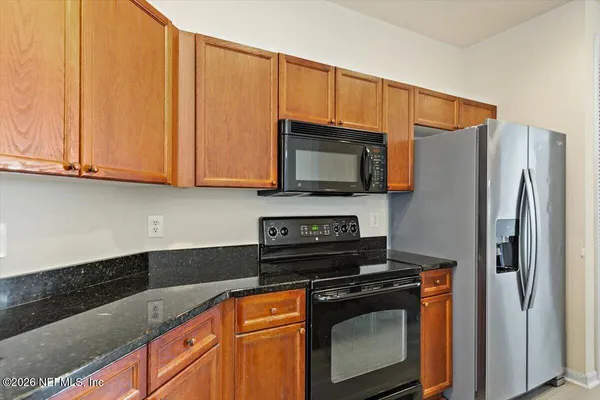 a kitchen with stainless steel appliances granite countertop a refrigerator stove and microwave