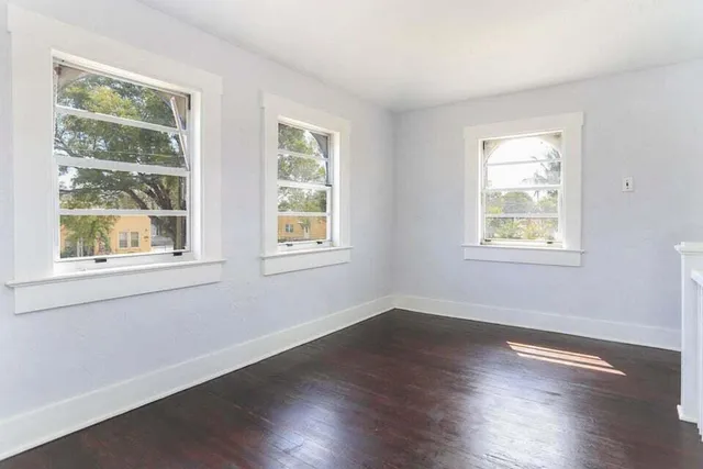 a view of a room with wooden floors and windows