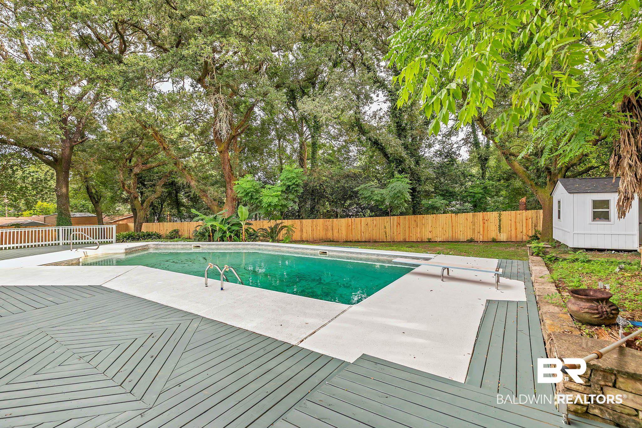 4705 Sherry Court Mobile, AL 36693 - Photo 66 of 100 View of swimming pool featuring a fenced backyard, a deck, a patio, a storage shed, and a diving board