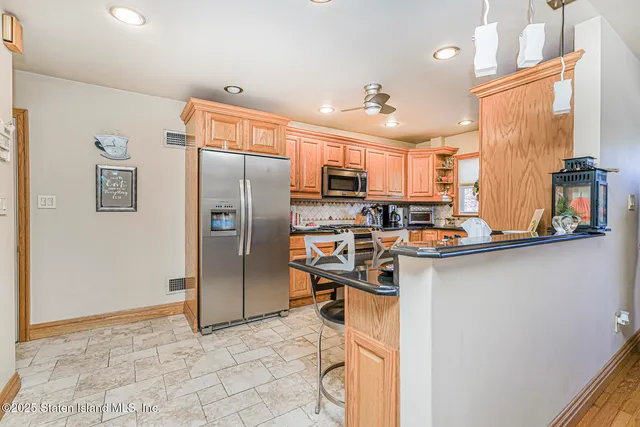 a kitchen with stainless steel appliances granite countertop a refrigerator and a sink