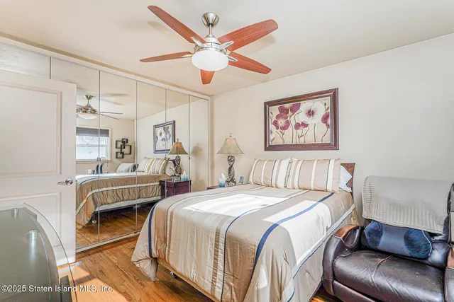 a bedroom with a bed a couch and a chandelier