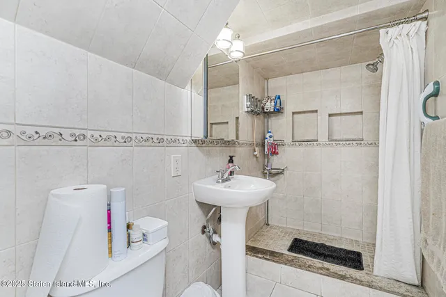 a bathroom with a sink mirror and shower