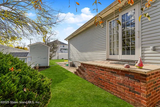 a backyard of a house with wooden floor and fence and a bench
