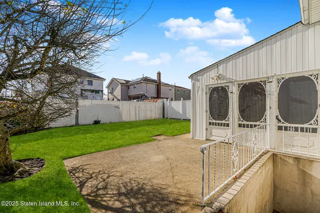 a view of a backyard with sitting area and garden