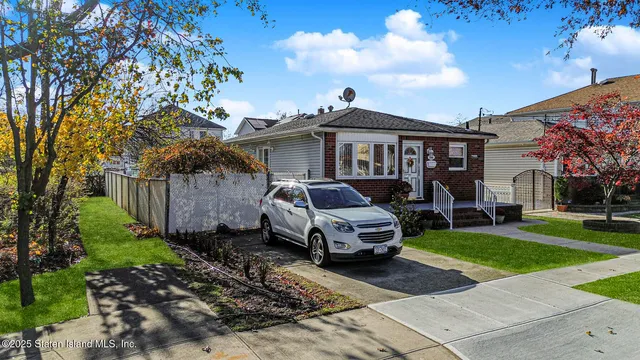a car parked in front of a white house