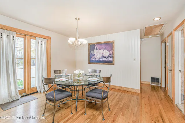 a dining room with furniture a chandelier and wooden floor