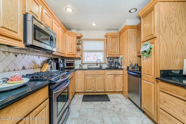 a kitchen with stainless steel appliances granite countertop a stove a sink and a refrigerator