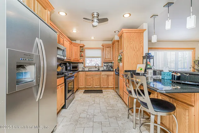 a kitchen with granite countertop a sink appliances cabinets and furniture
