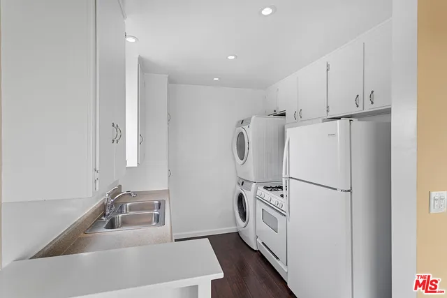 a kitchen with white cabinets and white appliances