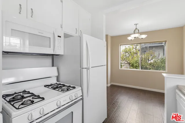a kitchen with a stove a refrigerator and a window