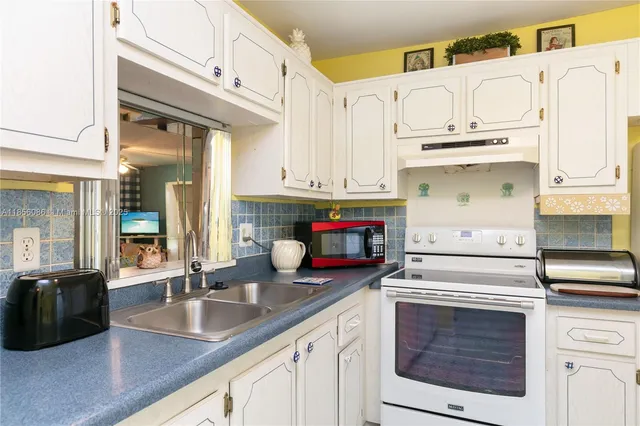 a kitchen with white cabinets and white appliances