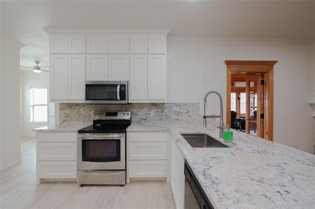 364 Parker Road, Unit A Van Alstyne, TX 75495 - Photo 12 of 39 Newly remodeled, spacious kitchen and new appliances, featuring white cabinetry, stainless steel appliances, a double basin sink, and ample counter space with a light-toned stone finish