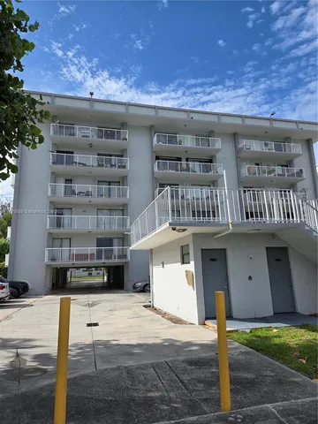 a front view of a building with a garden