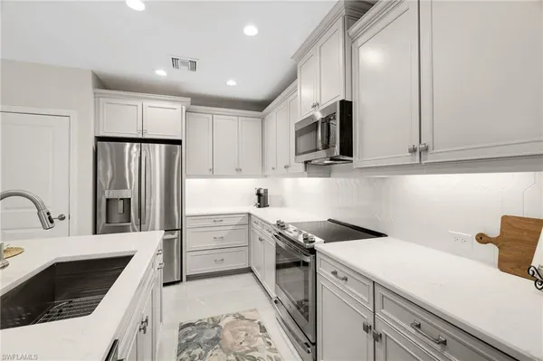 a kitchen with stainless steel appliances kitchen island granite countertop a sink and cabinets