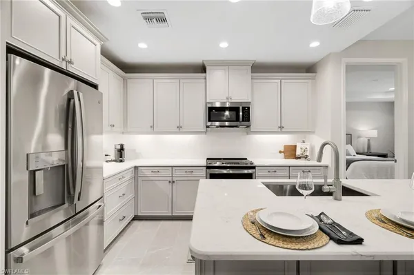 a kitchen with white cabinets sink and stainless steel appliances