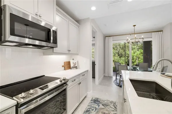 a kitchen with stainless steel appliances a white refrigerator a stove a sink and a dining table