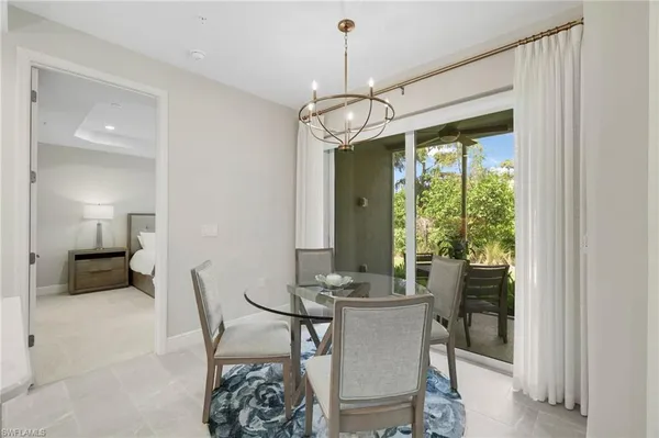a kitchen with stainless steel appliances a dining table chairs and white cabinets