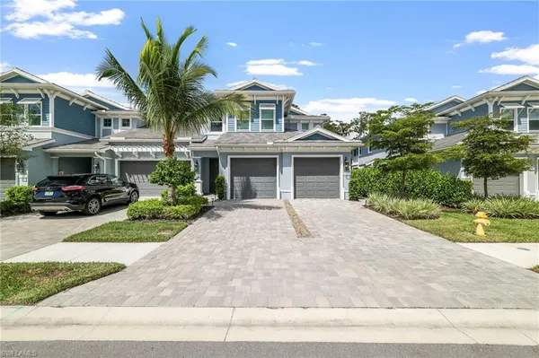 a front view of a house with a garden and parking
