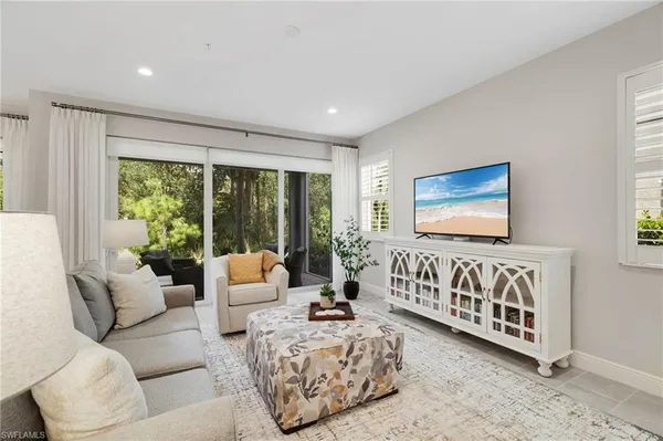 a living room with furniture fireplace and large windows