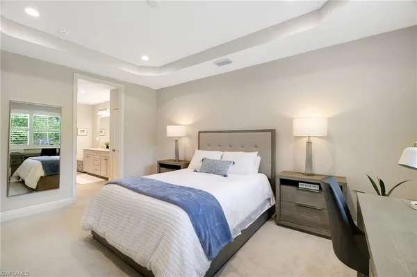 a bedroom with a large bed and a night stand