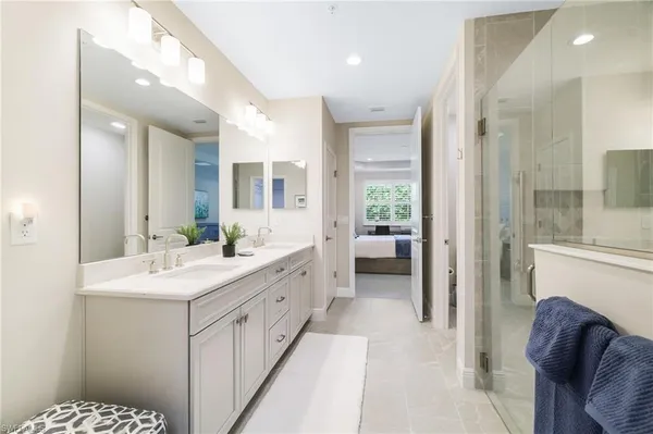 a bathroom with double vanity and a mirror