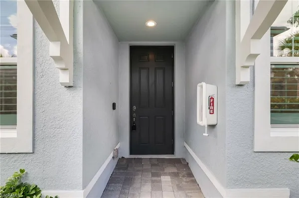 a view of a hallway with wooden floor and a bathroom