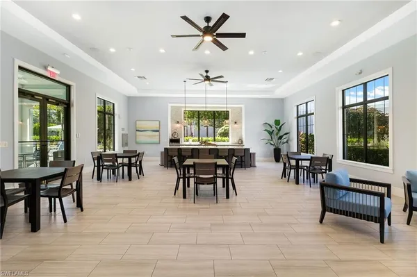 a dining hall with stainless steel appliances granite countertop a table and chairs