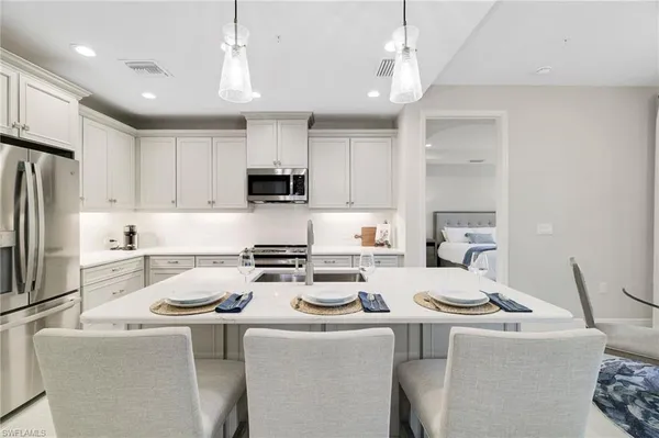 a kitchen with stainless steel appliances a white stove top oven a sink a refrigerator and a cabinets