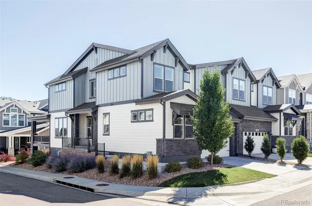 a front view of a house with a yard and tree s