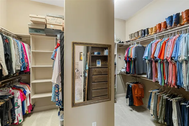 a view of walk in closet with clothes and shoes