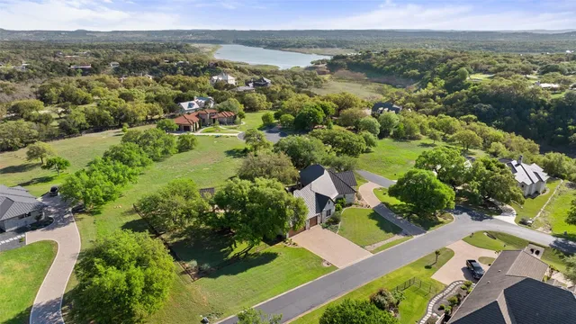 an aerial view of residential houses with outdoor space and trees