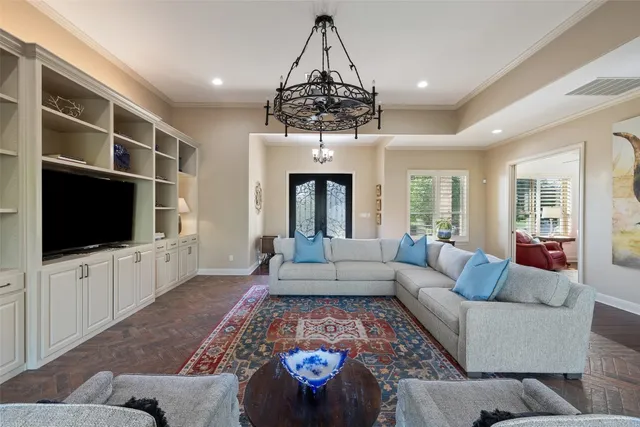 a living room with furniture a flat screen tv and a chandelier