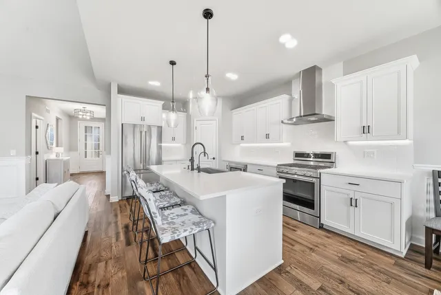 a large kitchen with stainless steel appliances kitchen island granite countertop a sink and cabinets