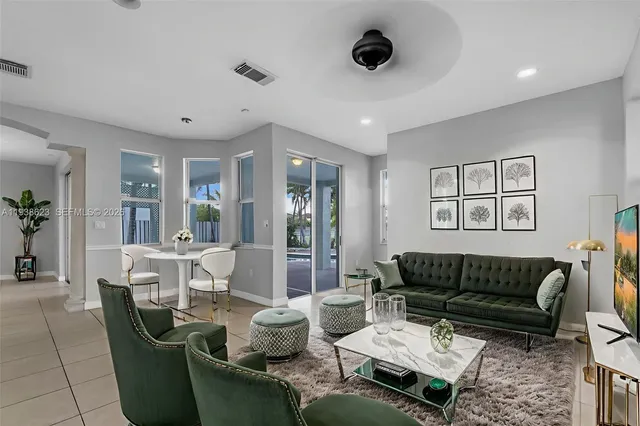a living room with furniture a large window and a dining table