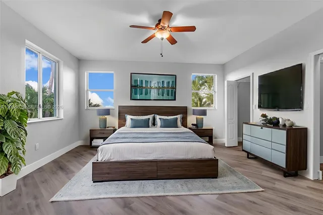 a bedroom with bed tv and window