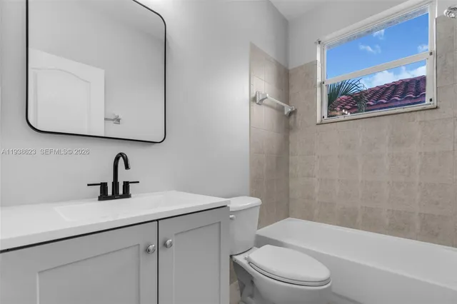 a bathroom with a sink a mirror a toilet and a bathtub