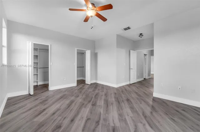a view of empty room with wooden floor and window
