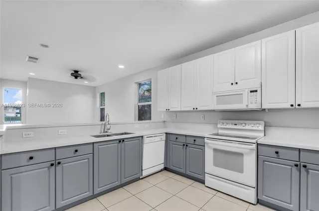 a kitchen with white cabinets stainless steel appliances and sink