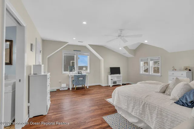 a spacious bedroom with a bed and a wooden floor