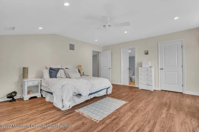 a spacious bedroom with a bed and a chandelier