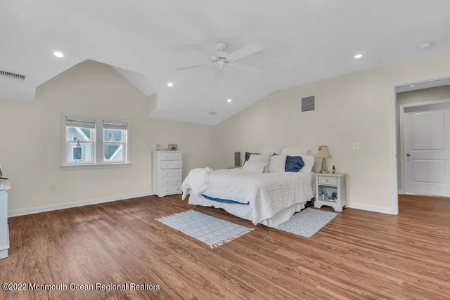 a spacious bedroom with a bed and a flat screen tv