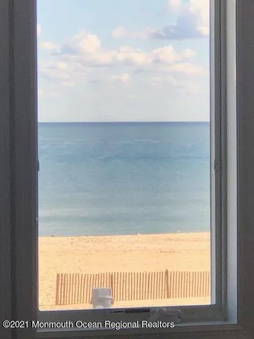 an aerial view of residential houses with outdoor space and ocean view