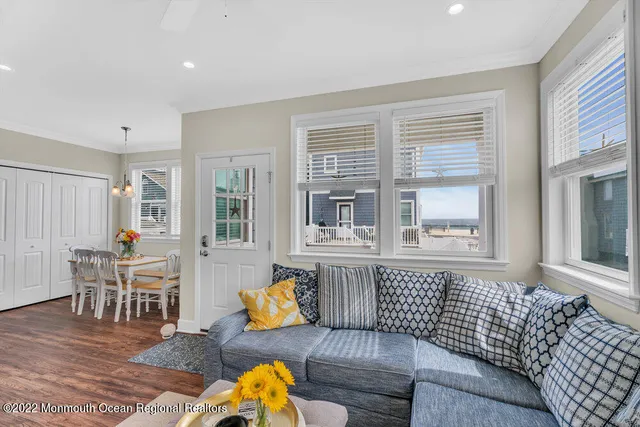 a dining room with chandelier fan and wooden floor