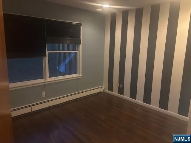 a view of a small space with wooden floor and a window