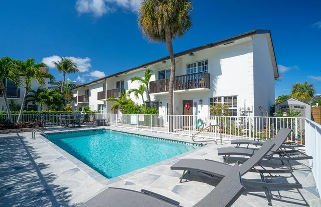 a view of a house with pool and sitting area