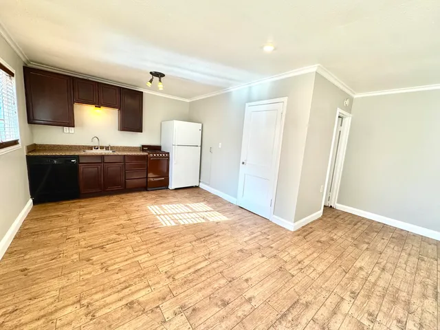 a large kitchen with granite countertop a refrigerator and a stove top oven