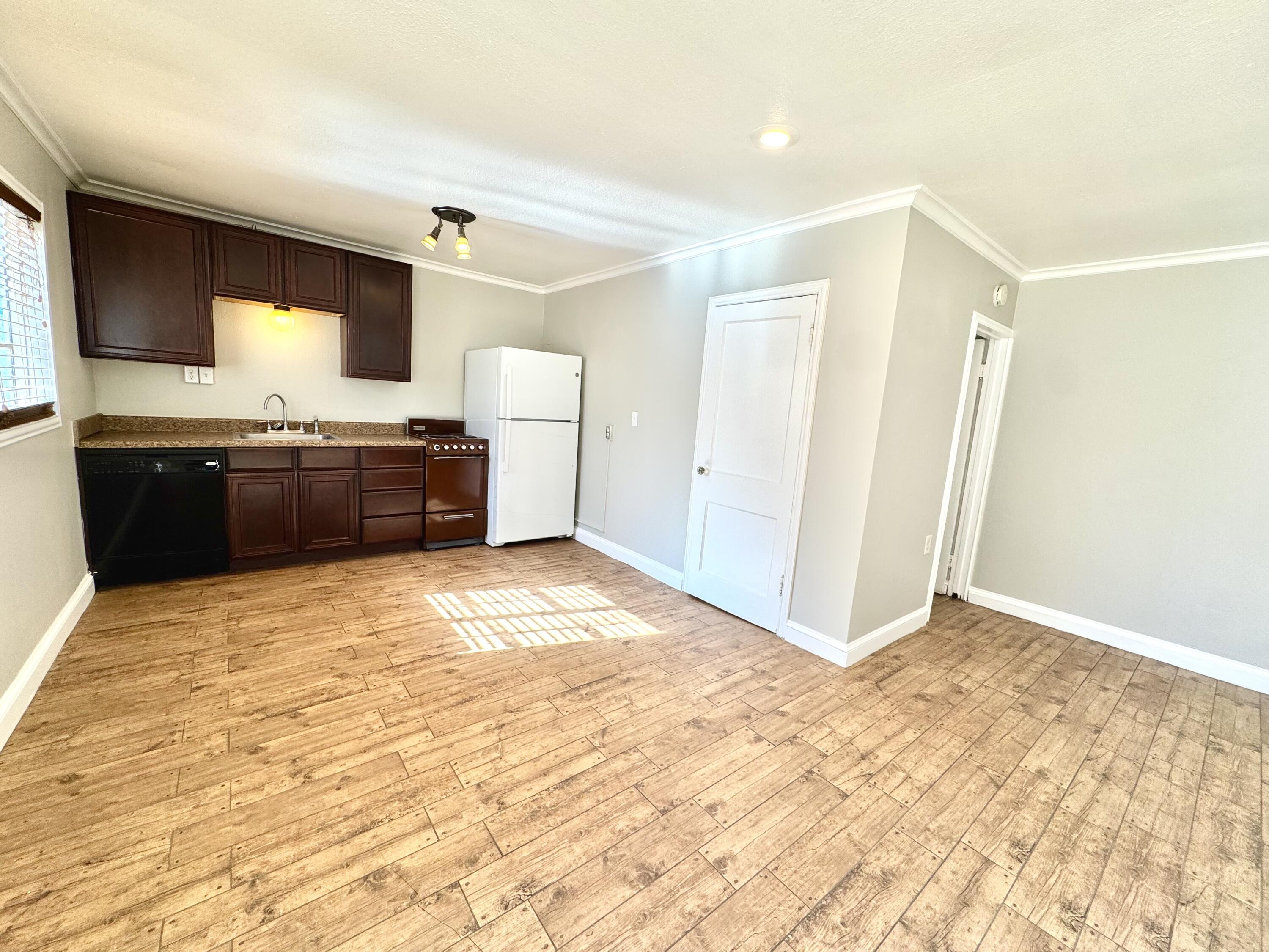2702 23rd Street, Unit B Lubbock, TX 79410 - Photo 2 of 9 a large kitchen with granite countertop a refrigerator and a stove top oven
