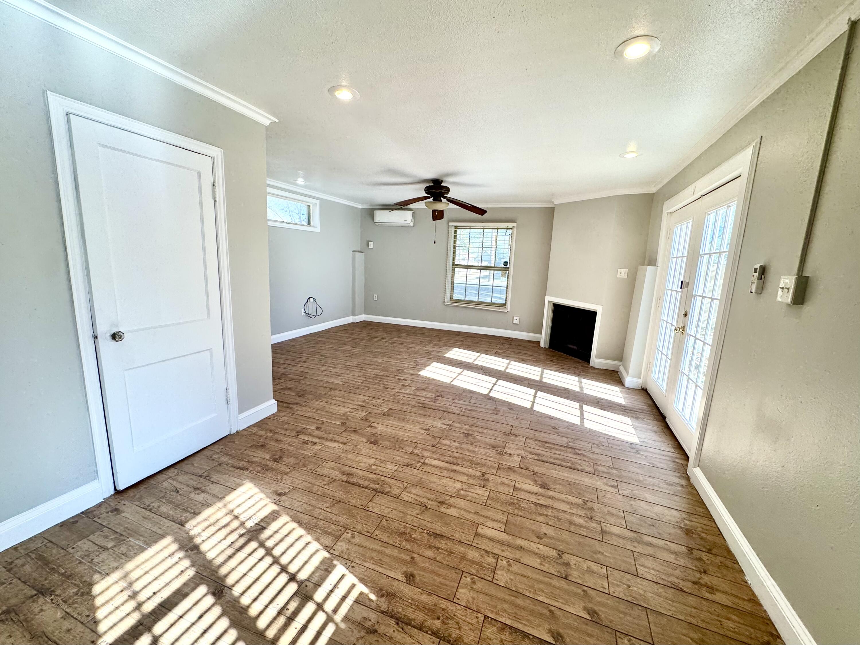 2702 23rd Street, Unit B Lubbock, TX 79410 - Photo 3 of 9 a view of a bedroom with a bed and wooden floor