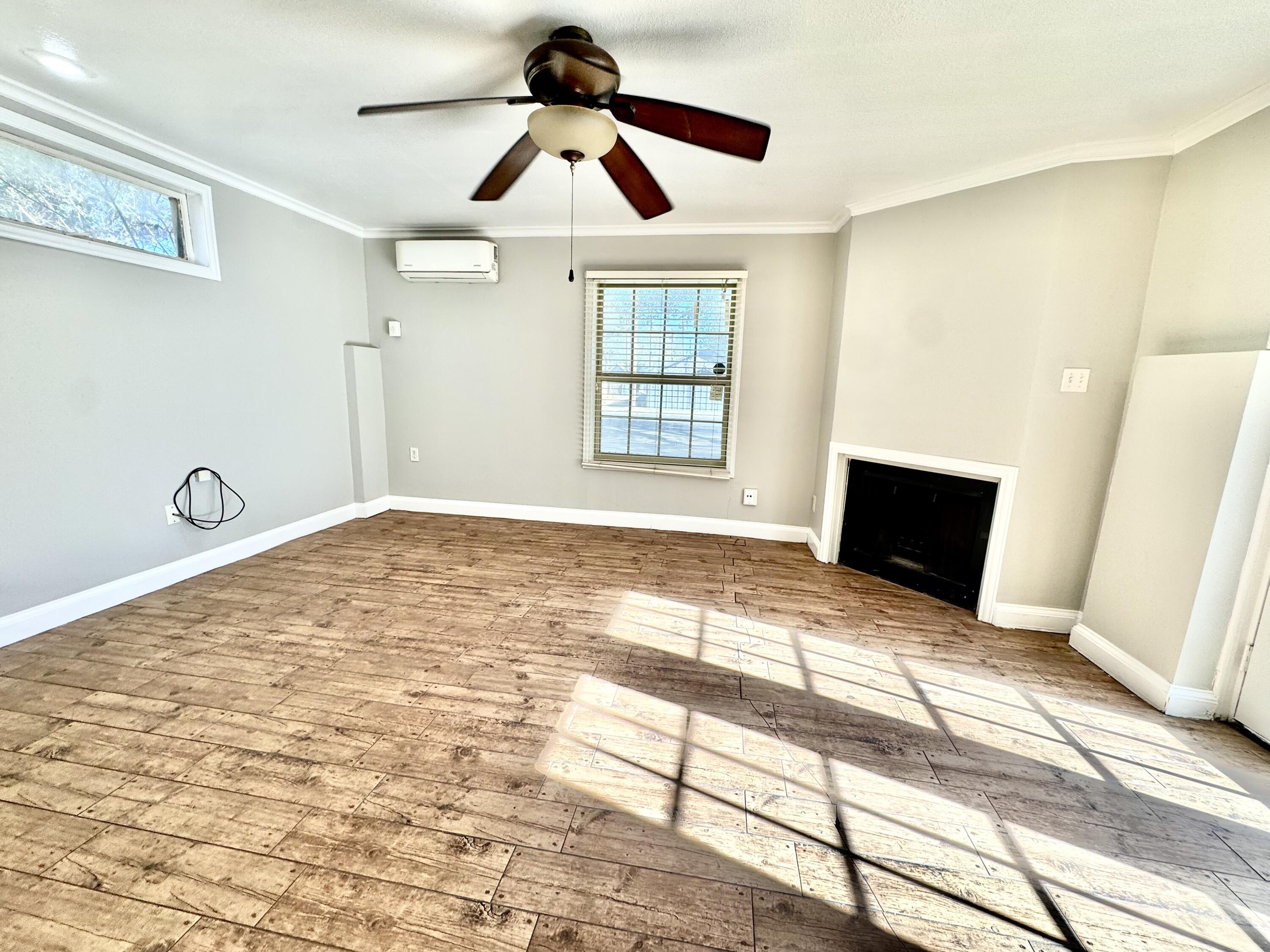 2702 23rd Street, Unit B Lubbock, TX 79410 - Photo 4 of 9 a view of empty room with wooden floor and fan